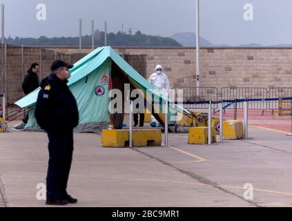 Pirée, Grèce. 3 avril 2020. Une garde côtière et un travailleur médical sont vus par une tente au Pirée, Grèce, le 3 avril 2020. Le ferry grec "Eleftherios Venizelos" avec 119 cas confirmés à bord a amarré au port du Pirée, comme le gouvernement grec a commencé vendredi le transfert à la rive de 261 passagers qui ont testé négatif pour la COVID-19, a rapporté L'agence nationale de presse grecque AMNA. Crédit: Marios Lolos/Xinhua/Alay Live News Banque D'Images