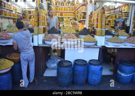 Les porte-olives mâles sont prêts à vendre leur récolte dans la médina de Marrakech, au Maroc, le soir de septembre. Banque D'Images