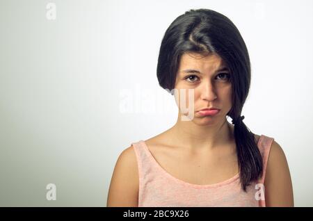 Portrait d'une jeune fille brunette avec pouting triste expression Banque D'Images