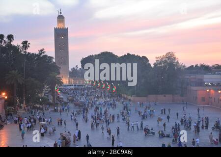 Photo aérienne Djemma El Fna, près de la Médina de Marrakech au Maroc, comme l'appel à la prière peut être entendu au coucher du soleil. Banque D'Images