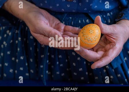 Oeufs de Pâques sorbiens, technique de batik de cire, cinquième étape: Après un premier bain de couleur, les premiers motifs peuvent être vus sur l'oeuf de poulet. Banque D'Images