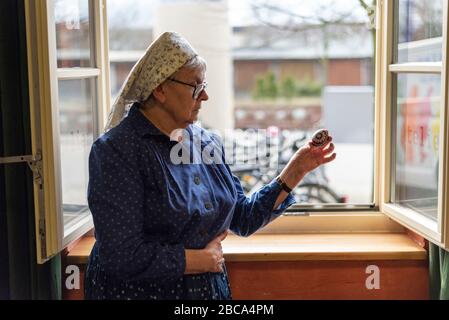 Une femme en robe sorabe tient un oeuf de Pâques orné Banque D'Images