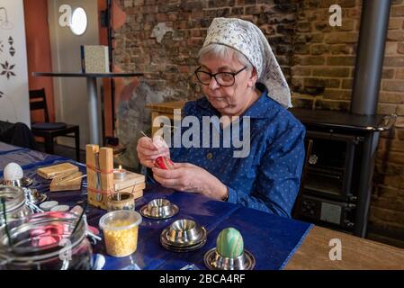 Une femme en robe sorabe décorera les œufs de Pâques. Banque D'Images
