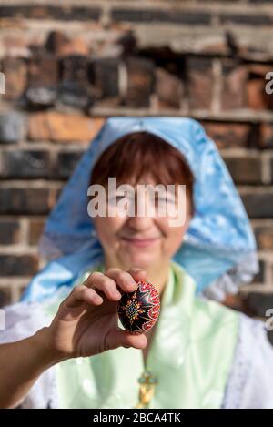 Une femme porte le costume sorabe, tenant un œuf de Pâques ornement dans ses mains. Banque D'Images