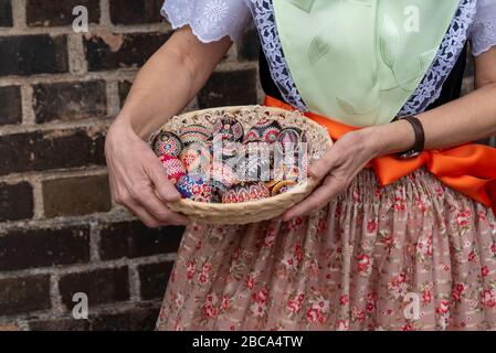 Une femme porte le costume sorabe, tenant un panier avec des œufs de Pâques décorés dans ses mains. Banque D'Images