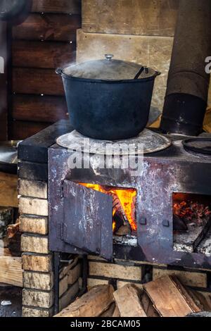 Un pot de soupe est cuit sur un vieux poêle en fer. Banque D'Images