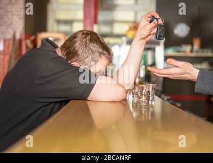 un homme ivre dans un bar se charge de sa clé de voiture Banque D'Images
