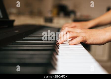 Enfants mains jouant piano.Cllase-up piano, clavier blanc et noir