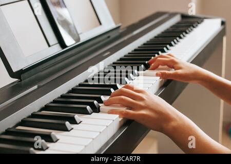 Enfants mains jouant piano.Cllase-up piano, clavier blanc et noir