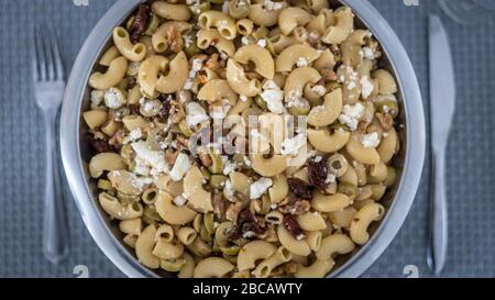 Vue de dessus d'une délicieuse salade de pâtes isolée sur une table à manger avec une fourchette et un couteau Banque D'Images