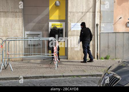 Une vieille femme au guichet automatique du bureau de poste pour retirer de l'argent. Mesure de sécurité requise par le gouvernement pour éviter le surpeuplement des bureaux publics. Banque D'Images