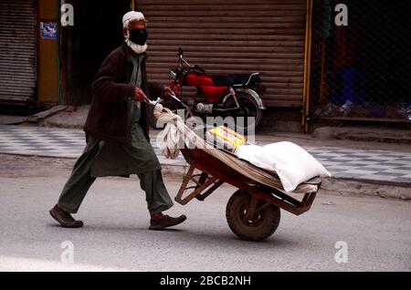 3 avril 2020 : Peshawar, Pakistan. 03 mars 2020. Les gens marchent dans une rue le long d'un marché fermé gardé par des policiers dans la ville pakistanaise du nord de Peshawar. Les marchés restent fermés à Peshawar dans le cadre de mesures de précaution visant à éviter la propagation de Covid-19 dans le pays crédit: Hasnain Ali/IMAGESLIVE/ZUMA Wire/Alay Live News Banque D'Images