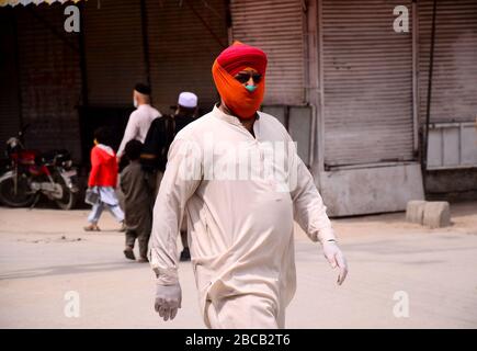 3 avril 2020 : Peshawar, Pakistan. 03 mars 2020. Les gens marchent dans une rue le long d'un marché fermé gardé par des policiers dans la ville pakistanaise du nord de Peshawar. Les marchés restent fermés à Peshawar dans le cadre de mesures de précaution visant à éviter la propagation de Covid-19 dans le pays crédit: Hasnain Ali/IMAGESLIVE/ZUMA Wire/Alay Live News Banque D'Images