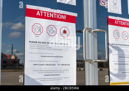 Panneau d'attention affiché dans un bureau du gouvernement du Canada au sujet des symptômes et des précautions de COVID-19. Banque D'Images