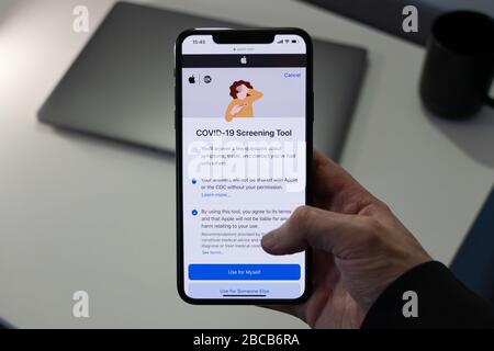 L'homme utilisant le site Web de l'outil de recherche COVID-19 développé par Apple Inc. Et le CDC pour le nouveau coronavirus. Banque D'Images
