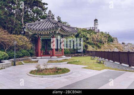 Pavillon coréen traditionnel sur le terrain de la maison de l'APEC Nurimaru avec ciel couvert et phare en arrière-plan Banque D'Images