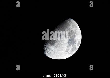 Demi-lune pendant le premier quart de phase isolée contre un ciel noir la nuit Banque D'Images