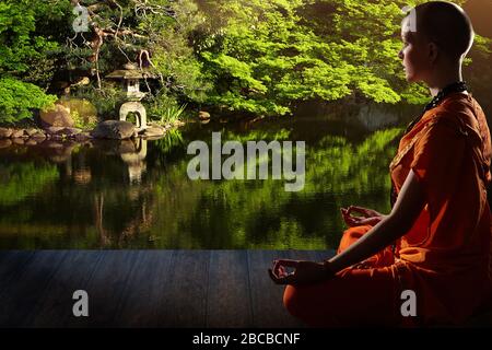Belle jeune femme en robe orange se trouve dans la méditation dans le jardin sur le plancher de bois..la méditation est la meilleure façon de résoudre le problème le plus complexe. Banque D'Images