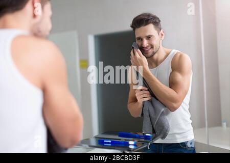 Jeune homme lave-visage dans salle de bains Banque D'Images