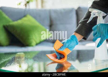 Biens essentiels pendant l'épidémie - prévention et protection du coronavirus COVID-19 propagation. Mains dans des gants désinfectants de surfaces avec aseptisant à la maison. Nettoyage contre le virus de la pneumonie. Banque D'Images