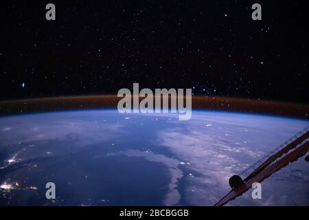 ISS - 4 mars 2020 - la teinte ambre plantant juste au-dessus du membre de la Terre est la lueur atmosphérique avec les étoiles de la voie lactée étincelant en arrière-plan Banque D'Images