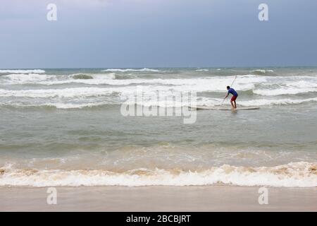 Surfer sur une circonscription à bord de tempête sur les vagues dans la mer Banque D'Images