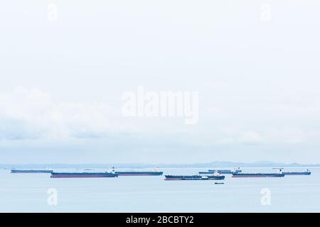 Les navires de fret, les pétroliers et les vraquiers sont ancrés au large du Singapore Straight, à Singapour, au coucher du soleil Banque D'Images