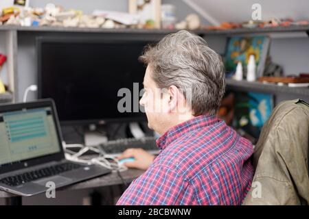 l'homme aux cheveux gris travaille dans la chambre du bureau à domicile Banque D'Images
