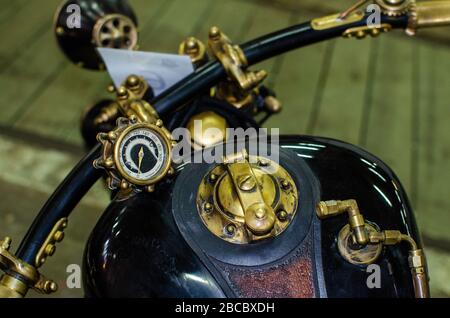 WROCLAW, POLOGNE - 11 août 2019: Les voitures des États-Unis montrent: Gros plan du réservoir et compteur de vitesse d'une moto ancienne de couleur noir et or brillant. Banque D'Images