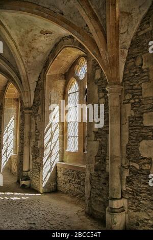 Soleil brillant par des fenêtres gothiques dans l'abbaye médiévale de Lacock, Wiltshire Banque D'Images