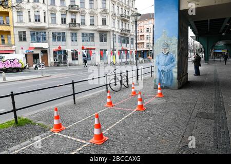 Berlin, Allemagne. 02 avril 2020. La zone d'attente du snack-bar Konopke sur Schönhauser Allee est clairement marquée par des marqueurs et des cônes de circulation. Les clients doivent conserver une distance minimale de 1,50 mètres. Un policier en uniforme historique est peint sur un pilier. Crédit: Jens Kalaene/dpa-Zentralbild/ZB/dpa/Alay Live News Banque D'Images