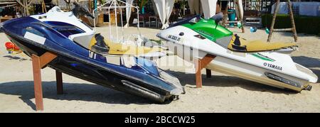 Deux jet ski colorés stationnés sur la plage de la saison des vacances. Vieux jet skis sur la plage sur remorque en bois. Blue and White Jet ski - Dubaï eau 20 janvier Banque D'Images