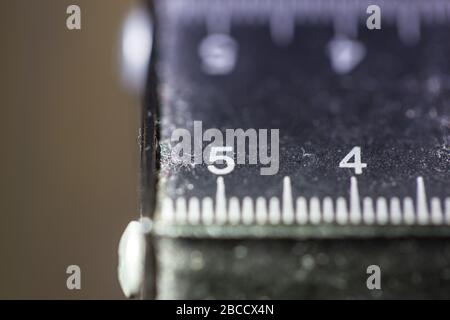 Vue macro de l'ancien instrument de mesure usé en pouces millimétriques Banque D'Images