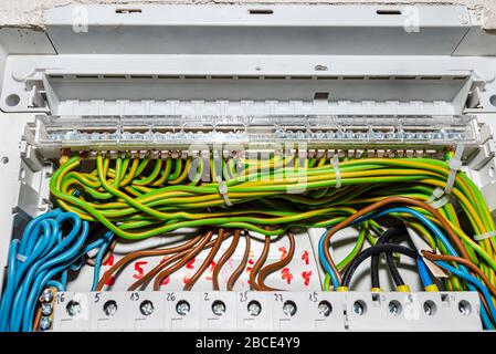 Bloc reliant les fils de mise à la terre vert-jaune avec les câbles connectés, installé dans le boîtier électrique. Banque D'Images