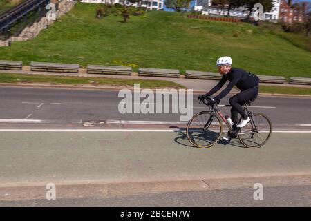 Southend-on-Sea, Royaume-Uni. 4 avril 2020. Un cycliste solitaire longe la piste cyclable désignée sur Western Esplanade, Southend-on-Sea, Essex, pendant le confinement COVID-19. La scène capture les infrastructures cyclables urbaines, la distanciation sociale et l’absence de circulation lors d’une chaude journée de printemps. Penelope Barritt/Alamy Live News Banque D'Images