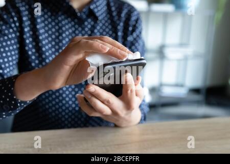 Gros plan sur l'écran du smartphone, les jeunes femmes indiennes désinfectent les mains. Banque D'Images