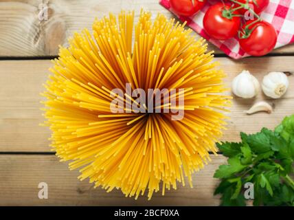 Pâtes spaghetti avec tomates ail et persil sur fond en bois. Couleurs du drapeau italien. Banque D'Images