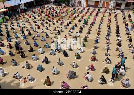Dhaka, Bangladesh - 04 avril 2020: Les sans-abri bangladais attendent dans une file d'attente d'obtenir de l'aide pendant le verrouillage national imposé comme mesure aux précédent Banque D'Images