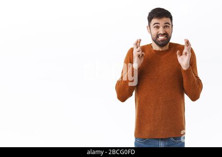 Portrait de la main nerveuse barbu gars dents s'inquiétaient, croisez les doigts bonne chance, priant et en attente d'espoir pour de bonnes nouvelles, rendant le souhait Banque D'Images