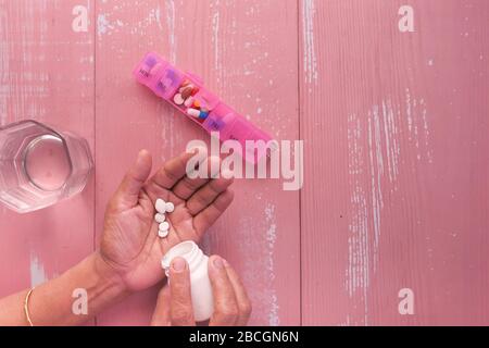 Femme âgée qui verse des pilules de la bouteille sur la main, vue de dessus Banque D'Images