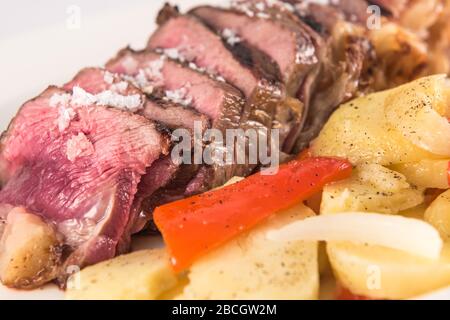 Plat à rouleaux de cubes de bœuf avec pommes de terre cuites en tranches. Banque D'Images