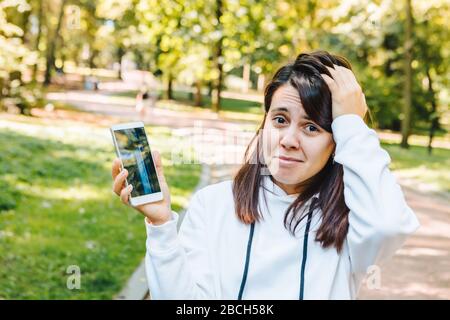 triste femme montrant écran mobile fissuré après le dépôt Banque D'Images