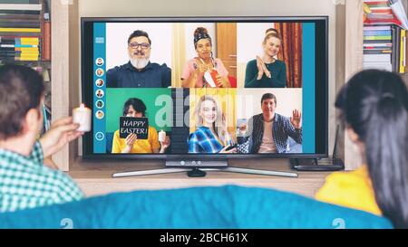 Des amis multiculturels à domicile pour célébrer les vacances de Pâques en ligne streaming en direct sur appel vidéo tenant des bougies et s'amuser en quarantaine Banque D'Images