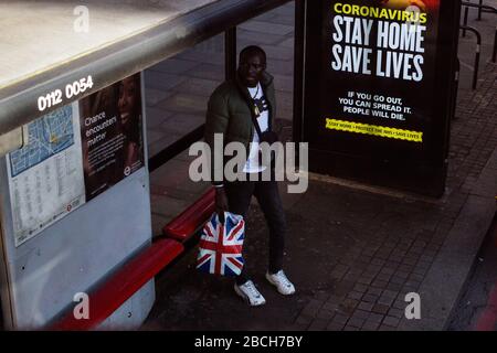 Londres Royaume-Uni 4 avril 2020 un homme se tient près d'une nouvelle publicité de marque NHS qui porte l'avertissement sans à-dire « si vous sortez, vous pouvez la diffuser. Les gens mourront. » Crédit: Thabo Jaiyesimi/Alay Live News Banque D'Images