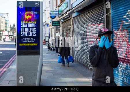 Londres Royaume-Uni 4 avril 2020 les gens passent devant une nouvelle publicité de marque NHS portant une image d'une femme dans des vêtements de protection tandis que l'avertissement émoussé clignote en disant : « si vous sortez, vous pouvez la diffuser. Les gens mourront. » Crédit: Thabo Jaiyesimi/Alay Live News Banque D'Images