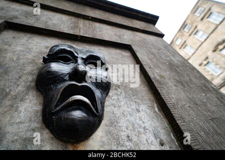 Masque théâtral relief en bronze avec un visage triste sur la tête de puits de High Street sur le Royal Mile à Édimbourg, en Écosse, au Royaume-Uni pour indiquer la tristesse de l'annulation du festival Edinburgh Flinge 2020. Banque D'Images