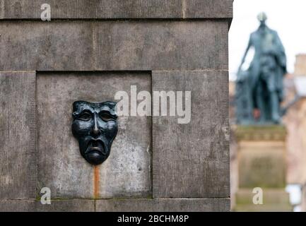 Masque théâtral relief en bronze avec un visage triste sur la tête de puits de High Street sur le Royal Mile à Édimbourg, en Écosse, au Royaume-Uni pour indiquer la tristesse de l'annulation du festival Edinburgh Flinge 2020. Banque D'Images