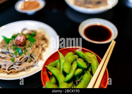 Bol japonais traditionnel au restaurant ou kaiseki ryokan avec encas à base de légumes à base d'edamame bouilli avec des baguettes de fermeture de couleur verte et salée et Banque D'Images