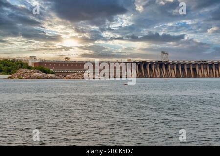 Vue panoramique sur le coucher du soleil depuis l'île de Khortytsia jusqu'à la rivière Dnieper et au barrage de la centrale hydroélectrique Dnipro à Zaporizhia, en Ukraine. Banque D'Images