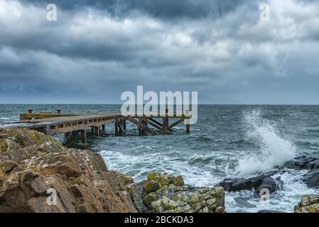 En regardant le port rocheux jusqu'à la vieille jetée de Portencross à Seamill West Kilbride sur une marche de tempête. Banque D'Images